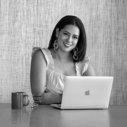 Jordana Moore Saggese, PhD, seated with laptop.